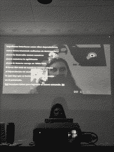 Room lit in blue: projection of the work’s text and, behind the projector, a person at the table